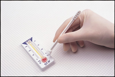 A person writing on a thermometer