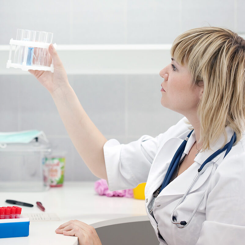 A woman holding up a box of pills.